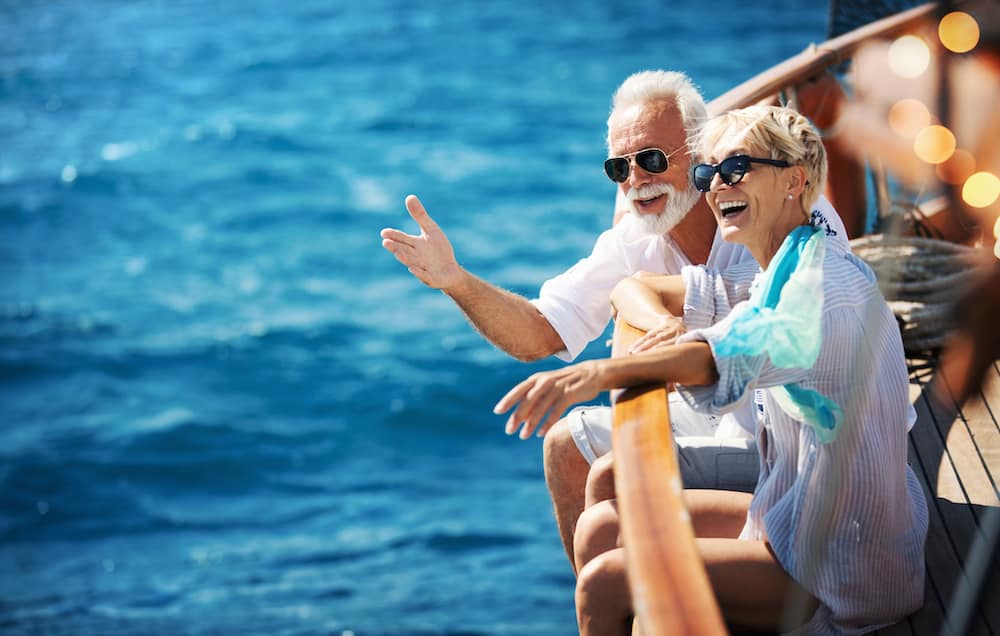 Senior couple on a sailing cruise - Should You Invest More Conservatively As You Get Older.